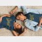 Mother and daughter duo lying down wearing raising a smart girl and smart like mama matching t-shirt